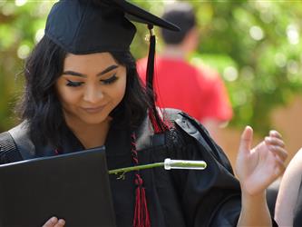 A student looking at her diploma. 