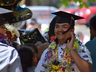 A kid eating his tassel. 